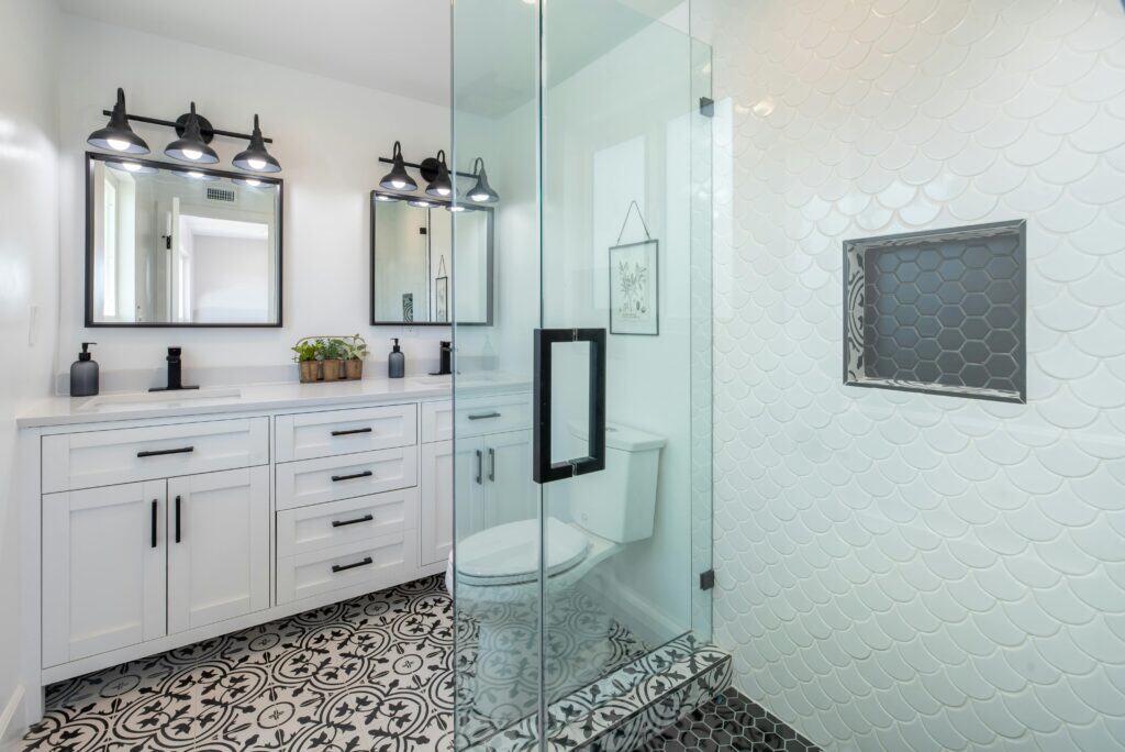 pexels-photo-2988865-2988865 Elegant white bathroom with glass shower and stylish patterned floor.